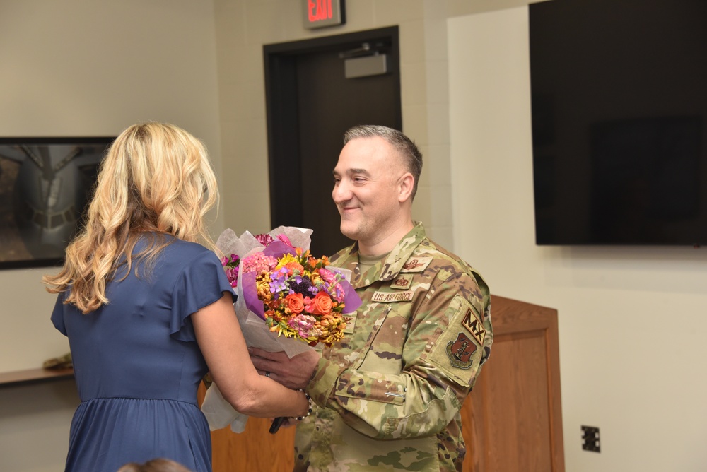 Col. Chad Schoonover hands flowers to his wife