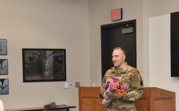 Col. Chad Schoonover prepares to hand flowers to his wife