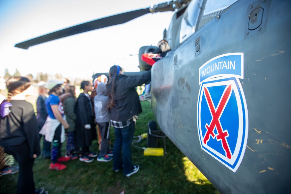 Students Approach an AH-64D Apache Helicopter