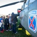 Students Approach an AH-64D Apache Helicopter