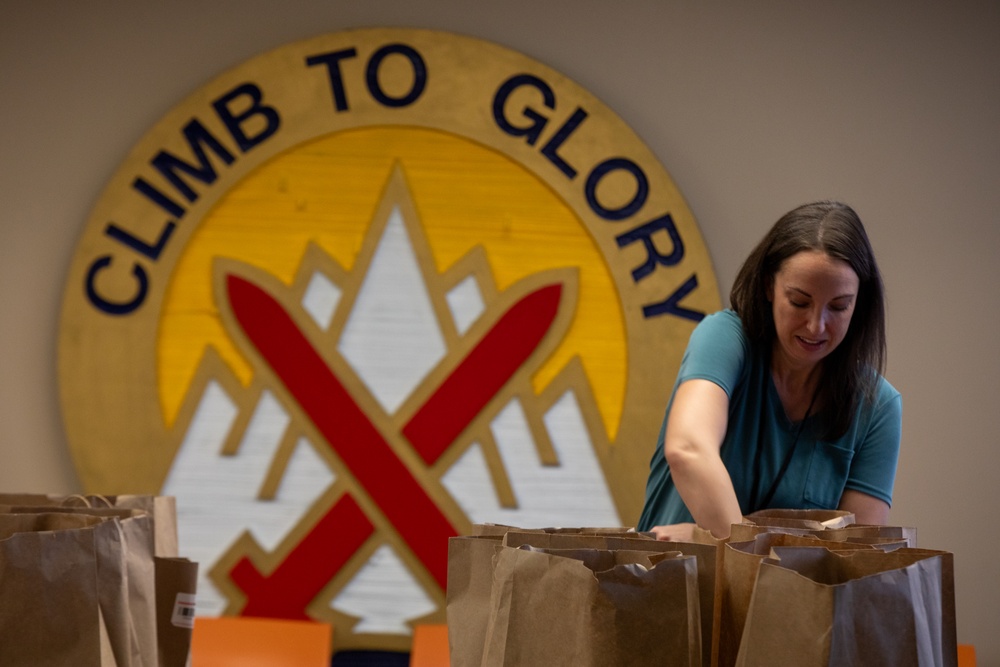 A battalion Soldier Family Readiness Group Leader Stuffs Bags for Soldiers