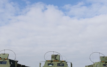 U.S. Soldiers and Romanian soldiers pose in front of HIMARS