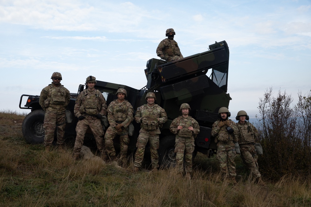 U.S. Soldiers pose in front of an Avenger Air Defense System