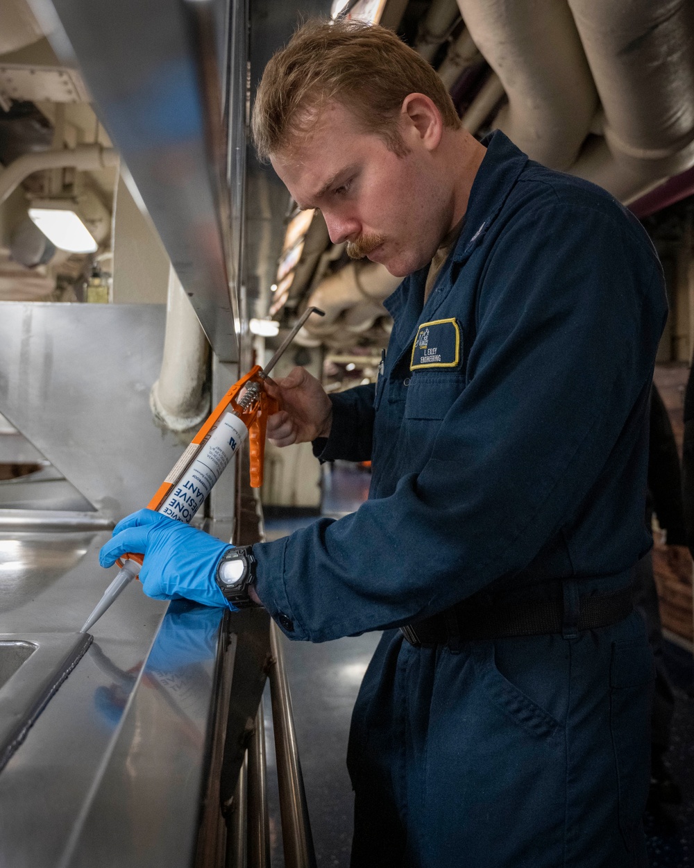 Nimitz Sailor Applies Caulking To Hot Plate Wells