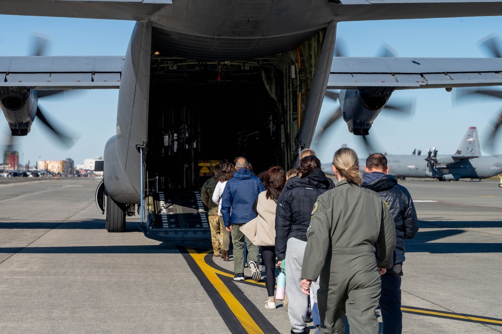 Spouses practice emergency evacuation through processing line, orientation flights