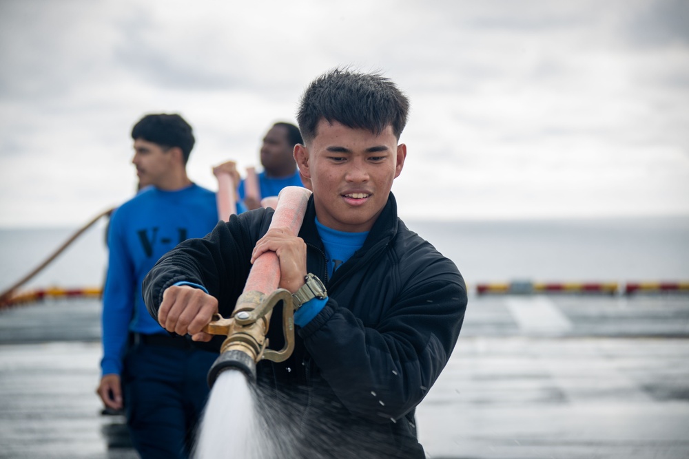 USS Tripoli Sailors wash the flight deck