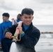 USS Tripoli Sailors wash the flight deck