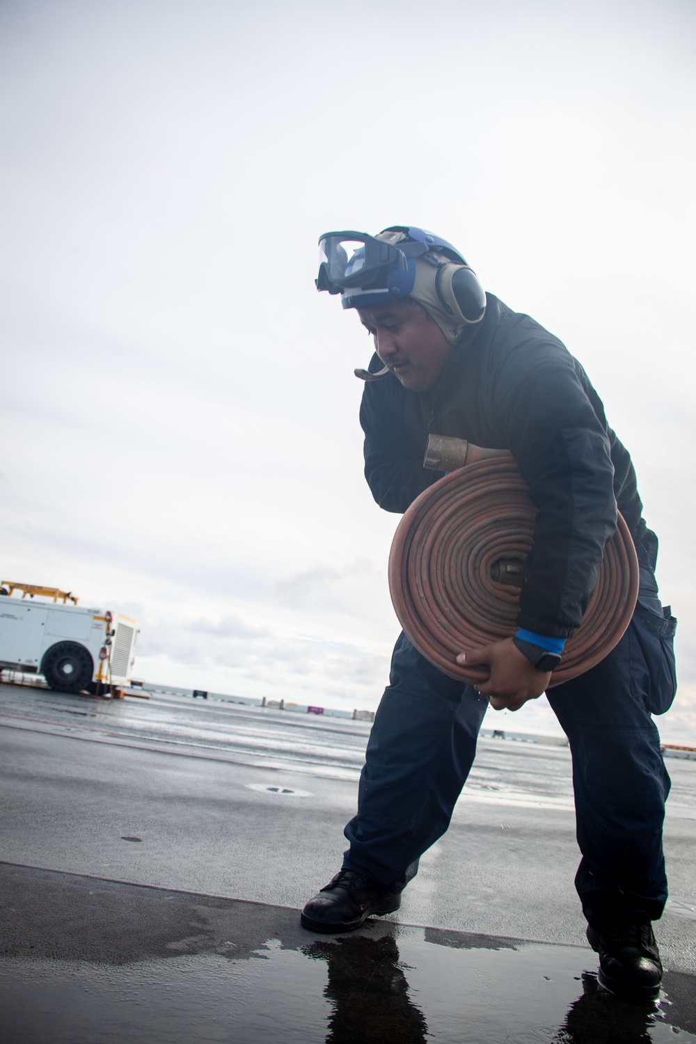 USS Tripoli Sailors wash the flight deck