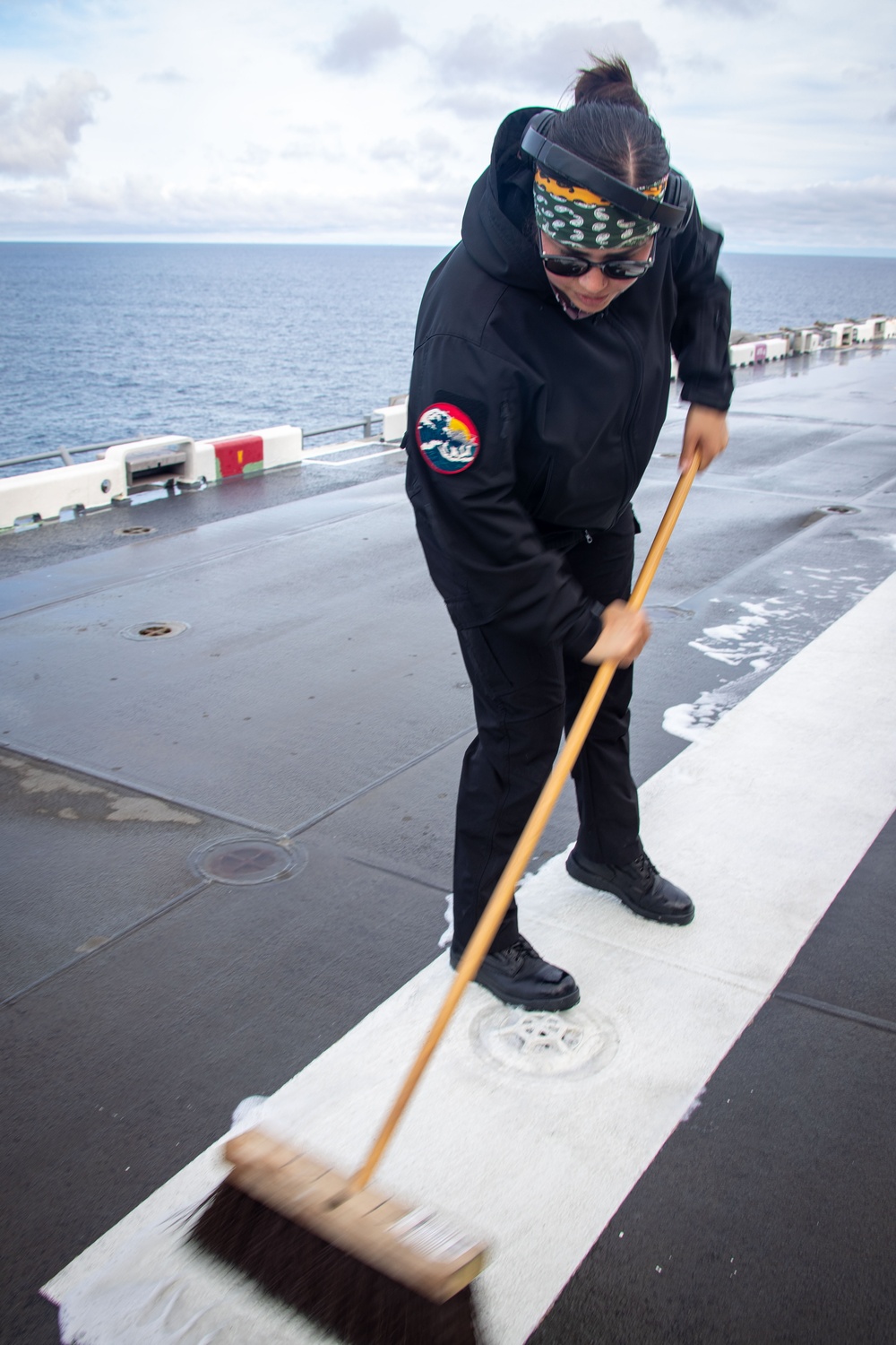 USS Tripoli Sailors wash the flight deck