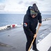 USS Tripoli Sailors wash the flight deck