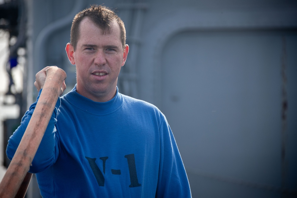 USS Tripoli Sailors wash the flight deck