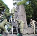 765th Transportation (Terminal) Bn. Soldiers, Japan Ground Self-Defense Force members work together to beautify historical stone monument on Camp Zama