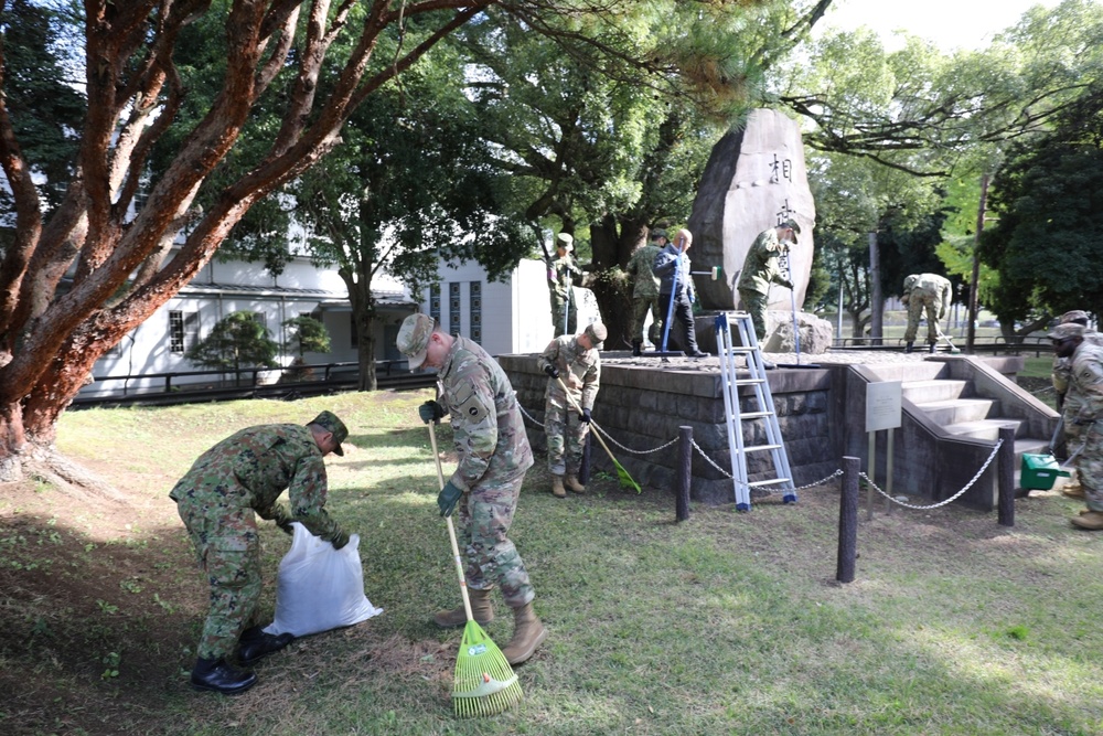 765th Transportation (Terminal) Bn. Soldiers, Japan Ground Self-Defense Force members work together to beautify historical stone monument on Camp Zama