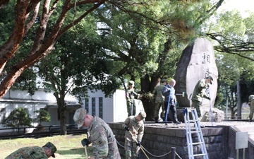 765th Transportation (Terminal) Bn. Soldiers, Japan Ground Self-Defense Force members work together to beautify historical stone monument on Camp Zama