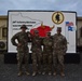 Soldiers paint concrete barrier.