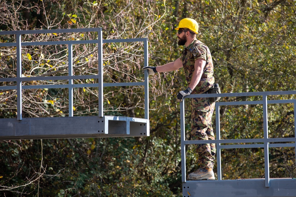 KFOR Swiss Army engineers construct a pedestrian bridge over the Ibar River