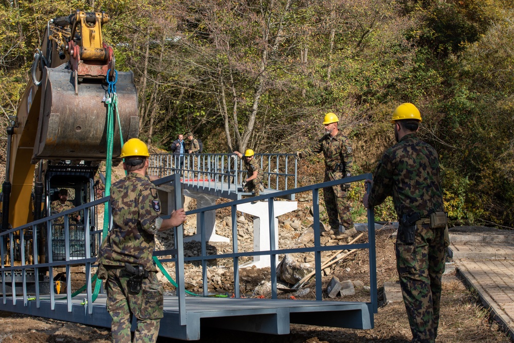 KFOR Swiss Army engineers construct a pedestrian bridge over the Ibar River