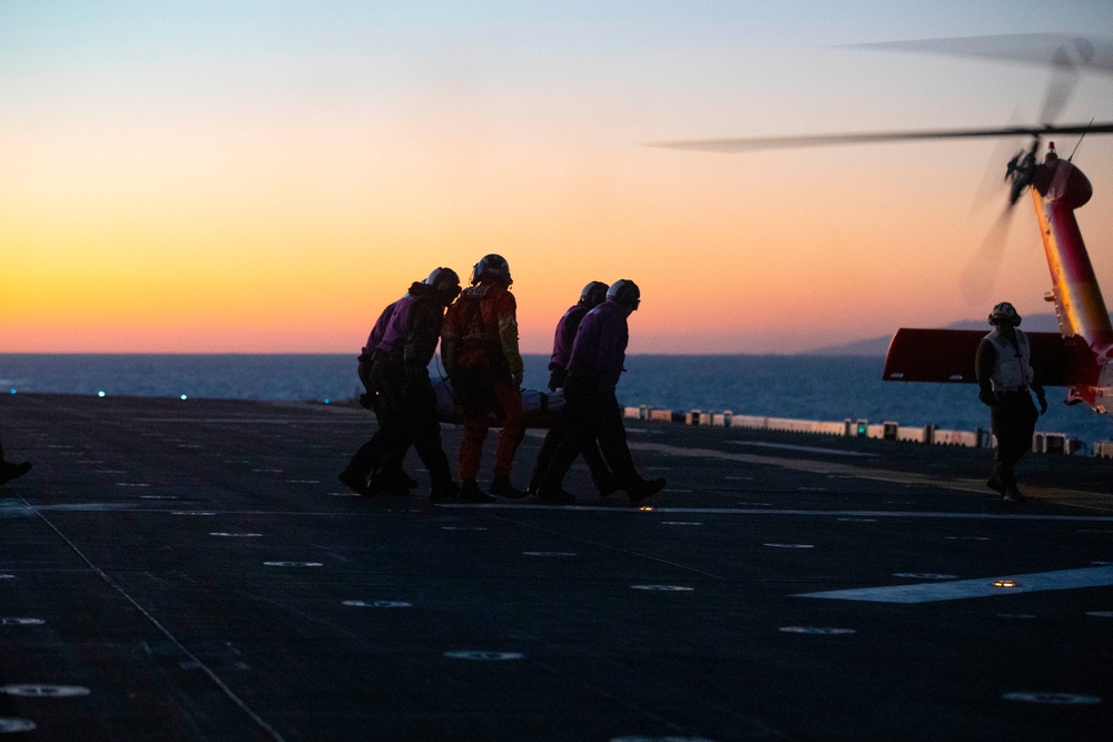 Sailors and Coast Guardsman medically evacuate a Sailor