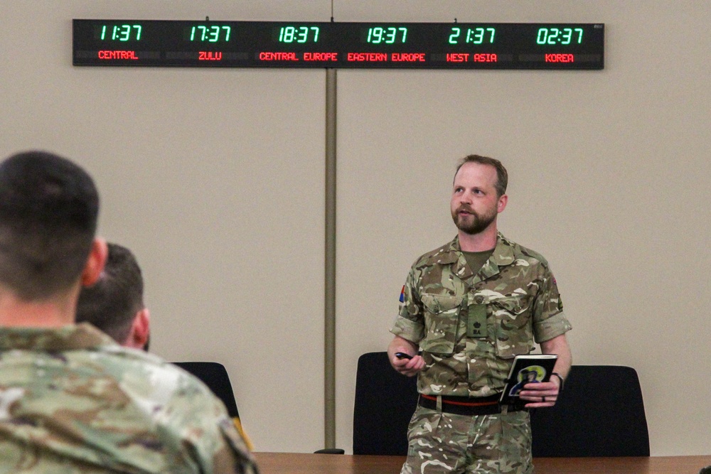 U.K. Maj. Christopher Wiggins, 3rd U.K. Division briefs Allied military and civilian planners