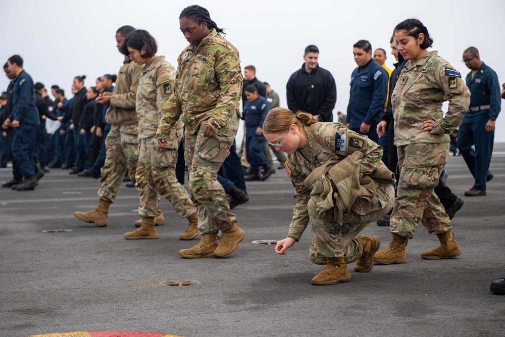 USS Ronald Reagan (CVN 76) Sailors and U.S. Army Soldiers participate in a FOD walk down