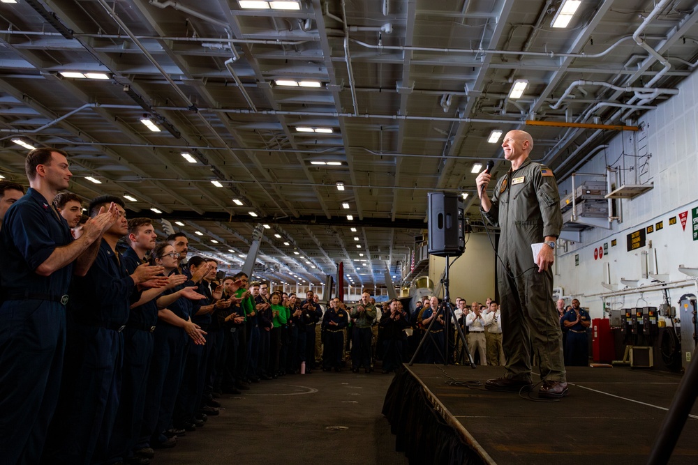 Abraham Lincoln conducts an all hands call in the hangar bay