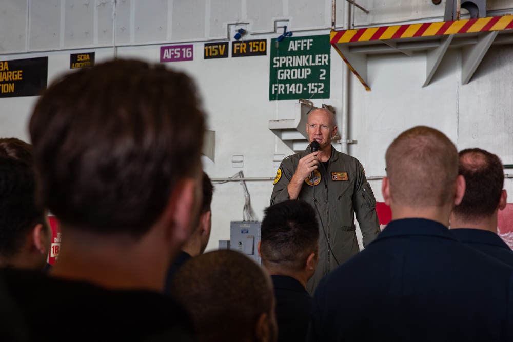 Abraham Lincoln conducts an all hands call in the hangar bay