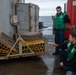 USS Ronald Reagan (CVN 76) Sailors transport gear on the flight deck