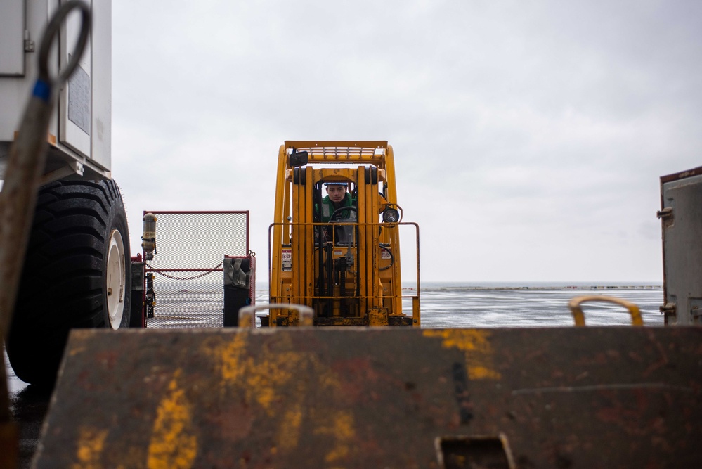 USS Ronald Reagan (CVN 76) Sailors transport gear on the flight deck