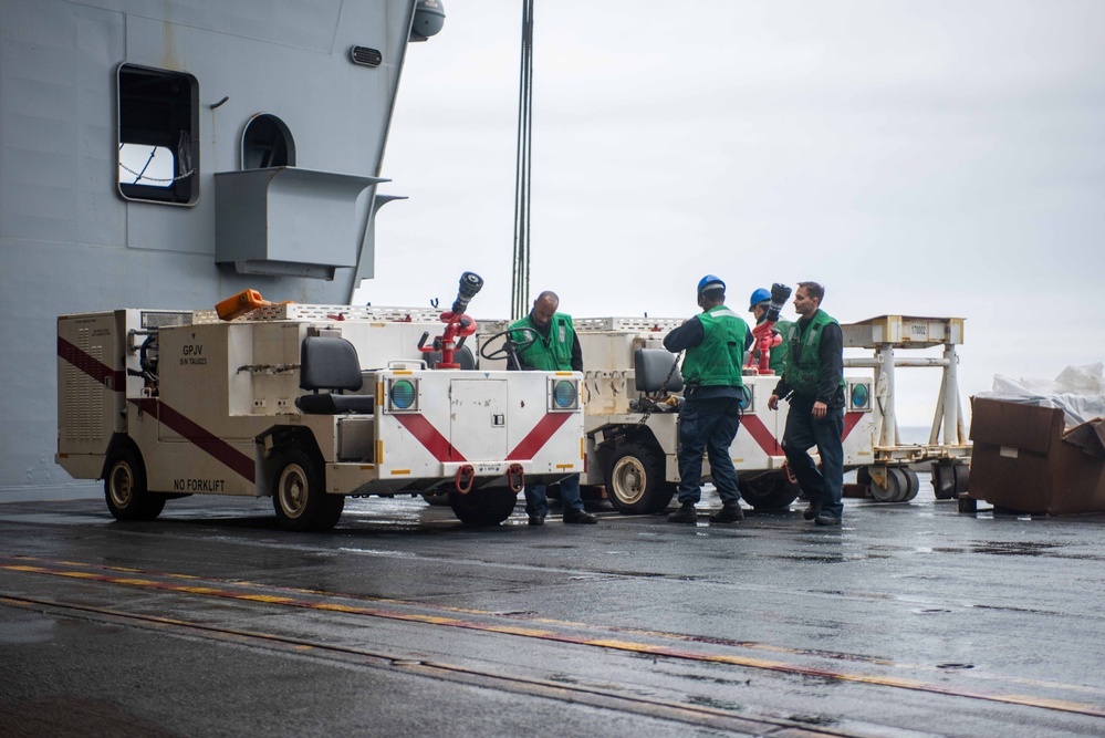 USS Ronald Reagan (CVN 76) Sailors transport gear on the flight deck