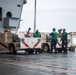 USS Ronald Reagan (CVN 76) Sailors transport gear on the flight deck