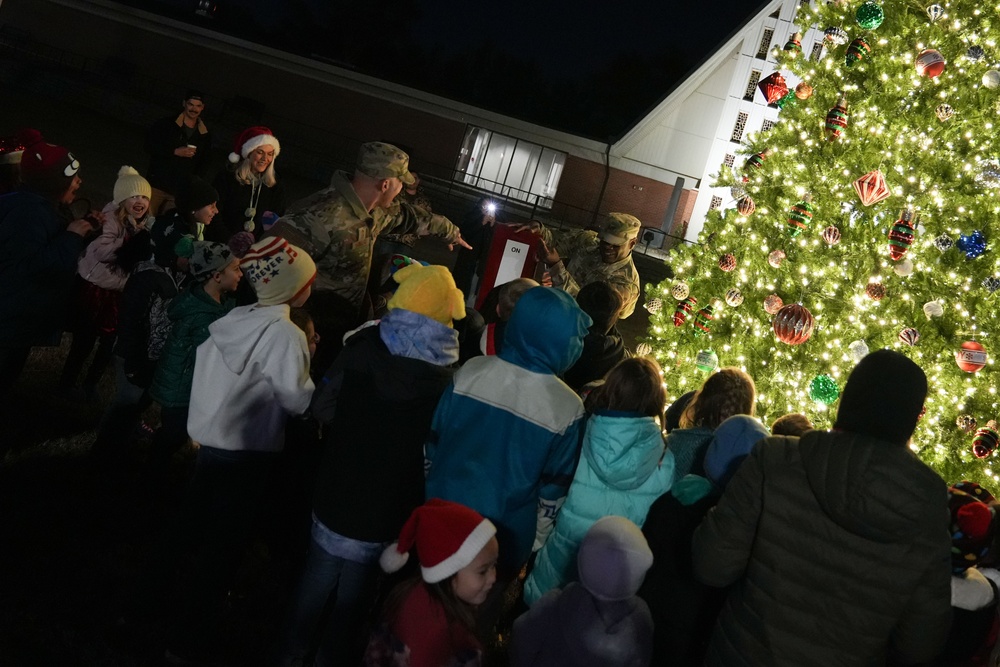 Col. Deedrick Reese, Robins Installation and 78th Air Base Wing commander, along with Team Robins children, illuminate the base tree.