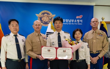 Col. Ronnie D. Michael, awards Mr. Ryu Deuk Gon Pohang Nambu Fire Station Chief with the Certificate of Commendation