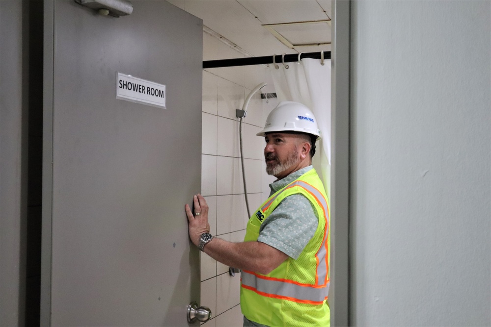 Safety personnel inspect showers during a safety inspection of H-2B visa worker barracks