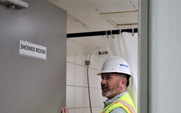 Safety personnel inspect showers during a safety inspection of H-2B visa worker barracks