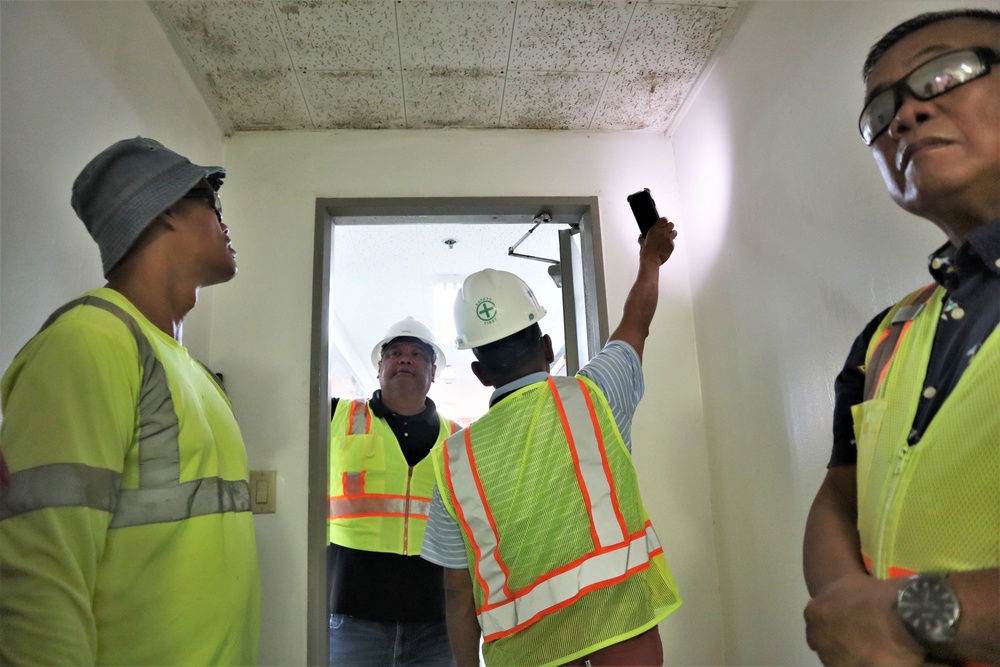 Safety personnel with the Office in Charge of Construction highlight safety concerns during a tour of H-2B visa worker barracks on a contractor-owned facility