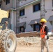 A spotter directs heavy equipment during the construction of Marine Corps Base Camp Blaz