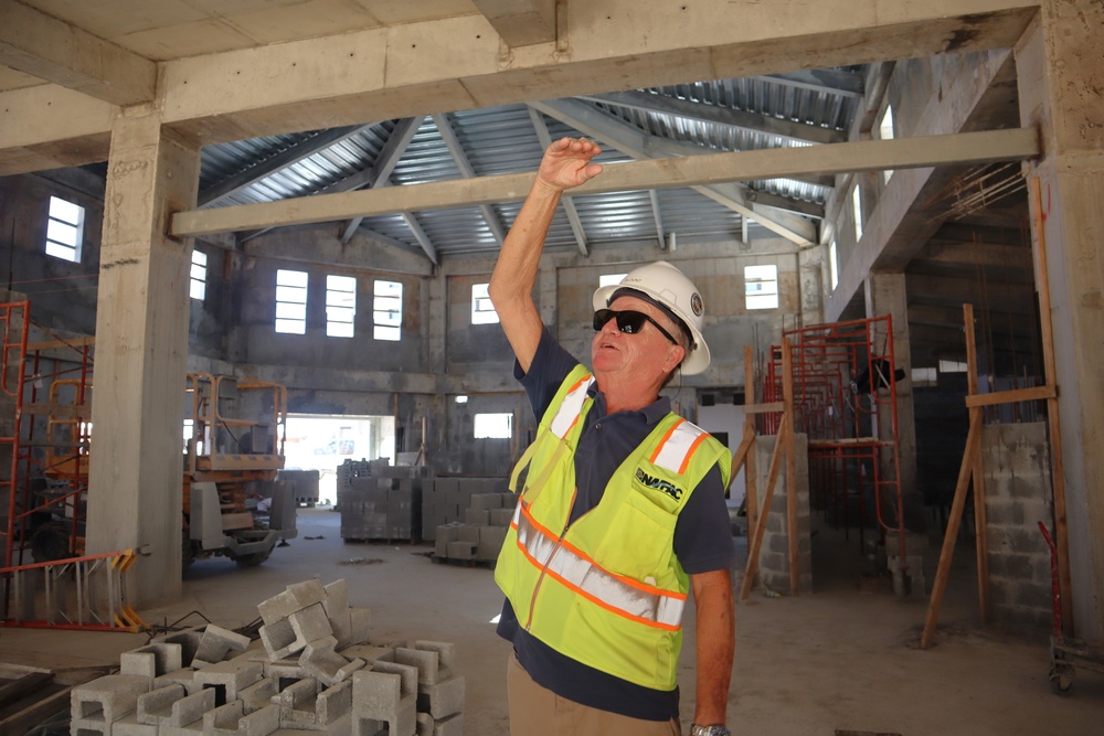 An Engineering Technician discusses key features in a community center under construction on Marine Corps Base Camp Blaz