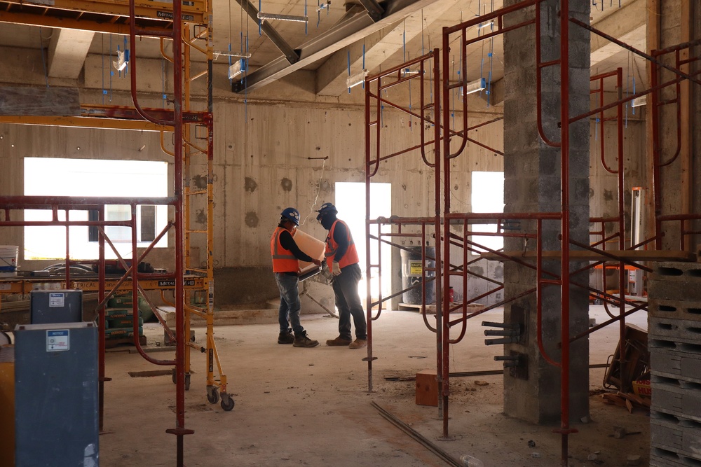 Contractors consult construction documents while making progress on a community center under construction on Marine Corps Base Camp Blaz