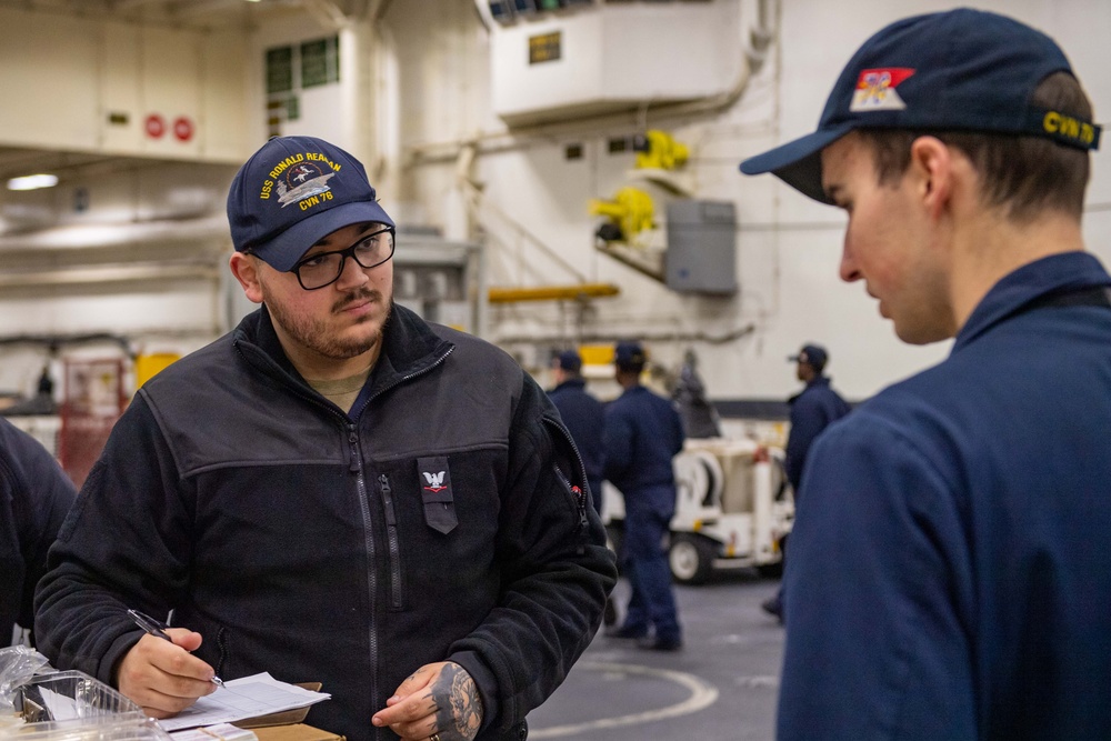 USS Ronald Reagan (CVN 76) Sailors issue personal protective equipment