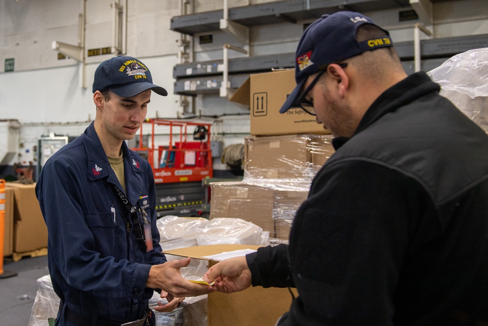 USS Ronald Reagan (CVN 76) Sailors issue personal protective equipment