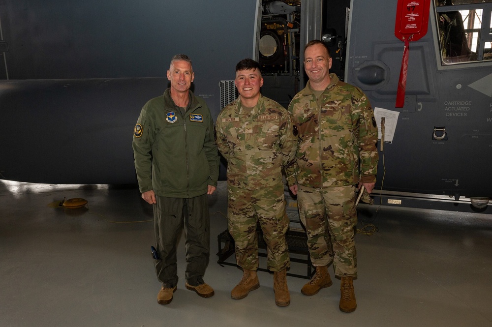 Maj. Gen. Gregory Kreuder, 19th Air Force Commander, and Chief Master Sgt. Keith Scott, 19th Air Force command chief, pose with Airman 1st Class Josue Quezada