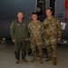 Maj. Gen. Gregory Kreuder, 19th Air Force Commander, and Chief Master Sgt. Keith Scott, 19th Air Force command chief, pose with Airman 1st Class Josue Quezada