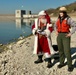 Santa Claus fishing while wearing a life jacket and talking to USACE park Ranger