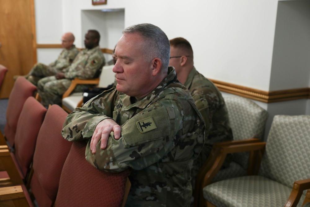 Service Member Kneel in Prayer During Religious Services