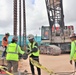 Crew Members Double-Check Coupling Components During a Crane Load Test