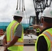 Safety Specialists with the Office in Charge of Construction Monitor for Safety Concerns During a Crane Load Test