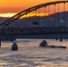 Sunfire and Ice: Towboats navigate through frozen rivers during Pittsburgh sunrise