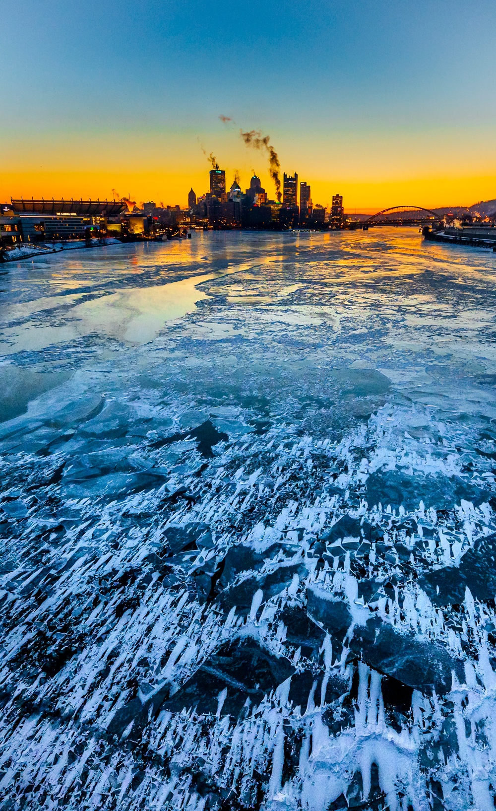 Sunfire and Ice: Towboats navigate through frozen rivers during Pittsburgh sunrise