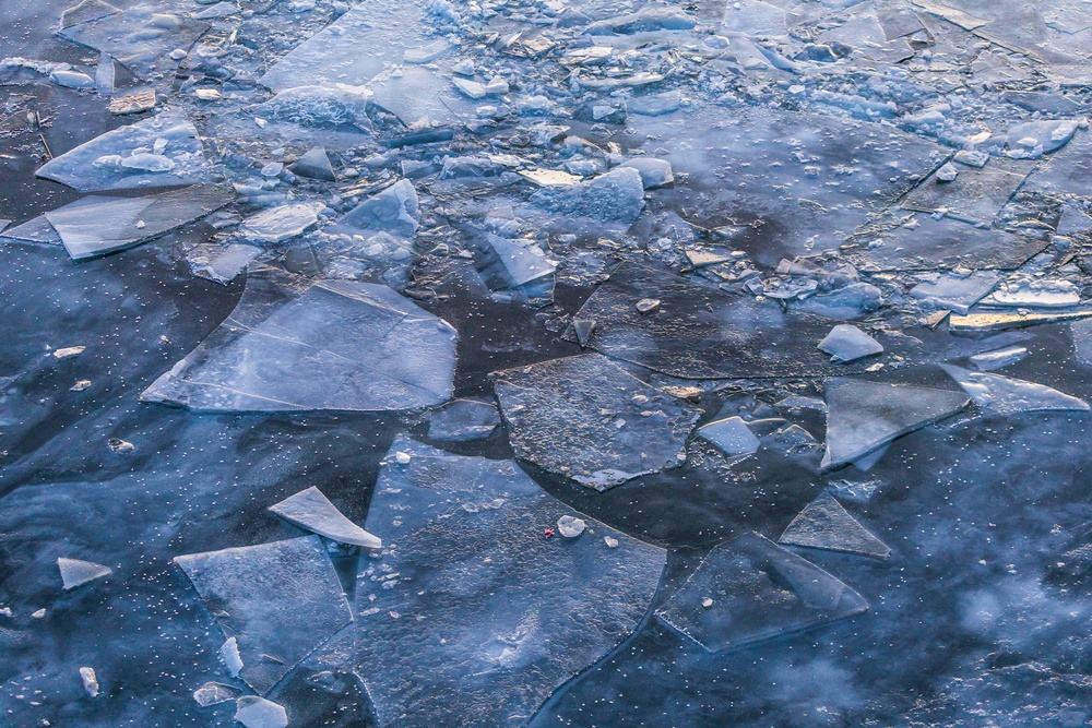 Sunfire and Ice: Towboats navigate through frozen rivers during Pittsburgh sunrise