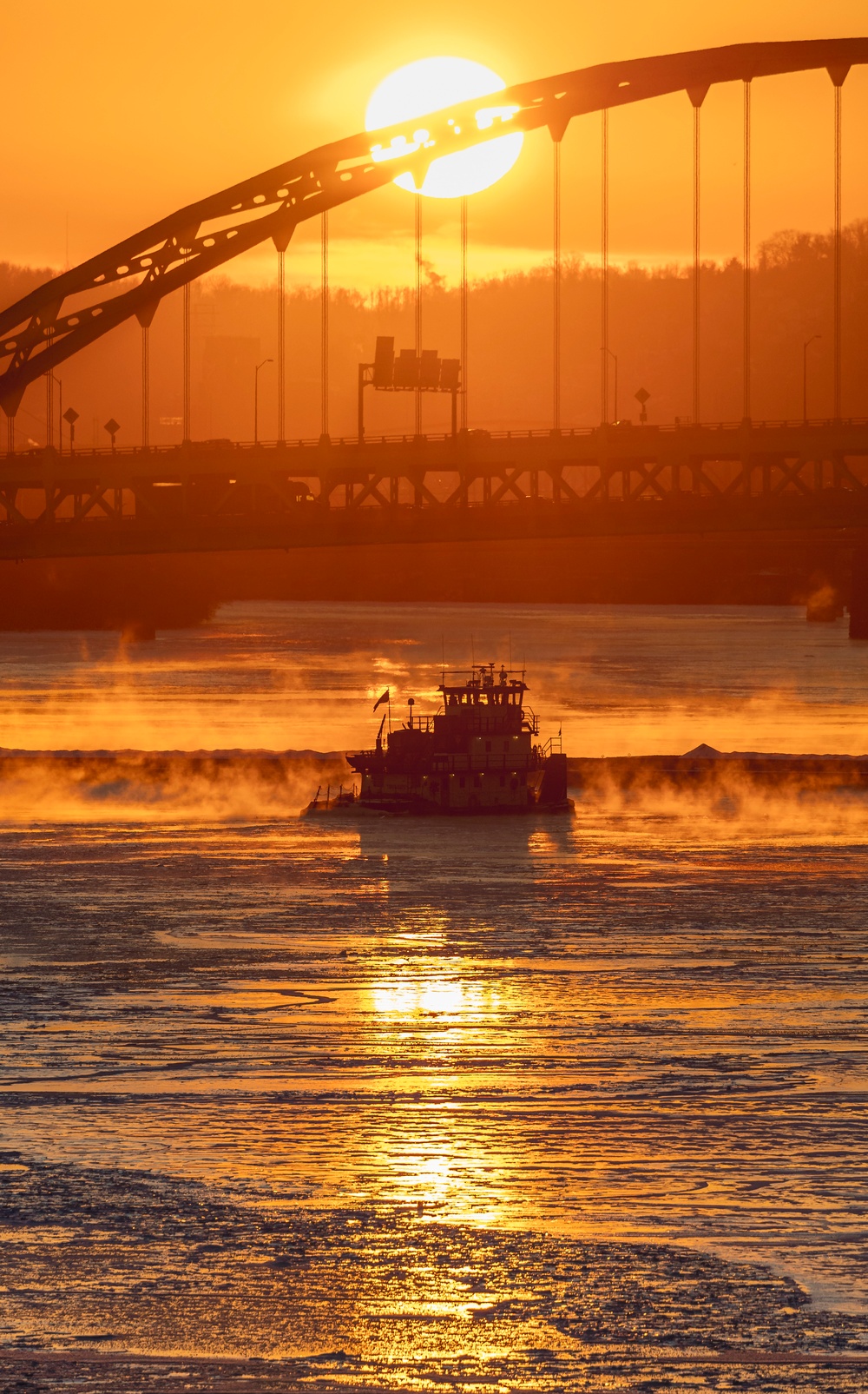 Sunfire and Ice: Towboats navigate through frozen rivers during Pittsburgh sunrise